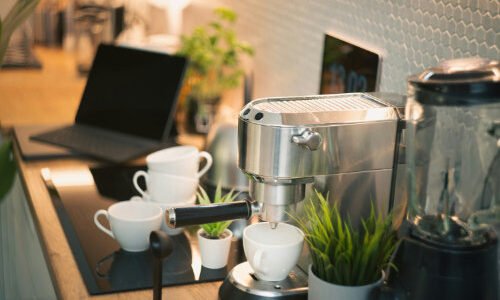Espresso machine with cups and laptop on counter small